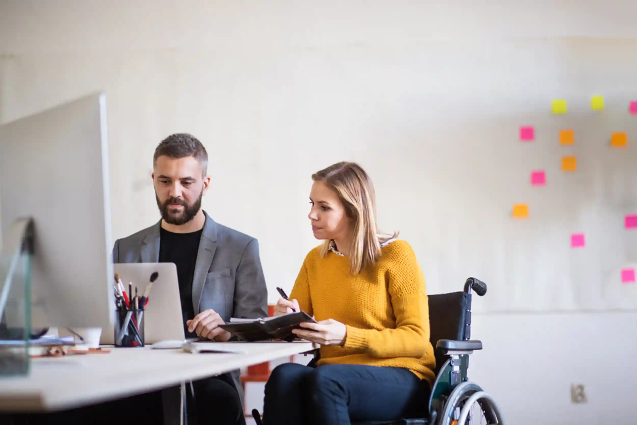 Two business people with wheelchair in the office