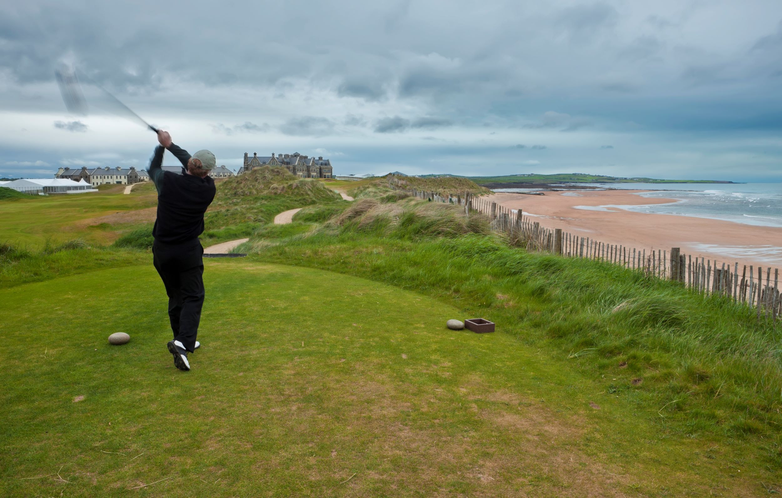Golfer teeing off at a links course in Ireland.
