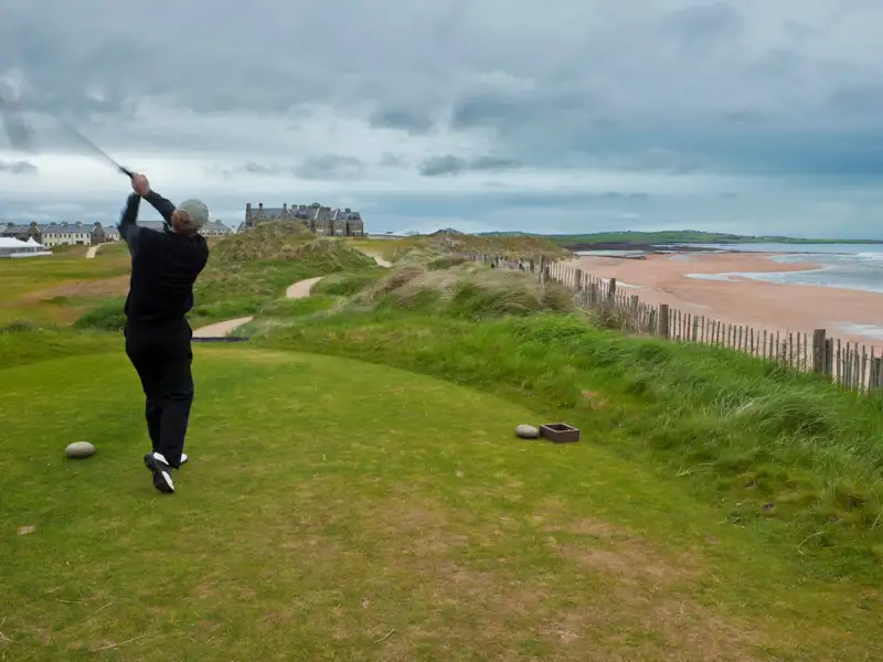 Golfer teeing off at a links course in Ireland.
