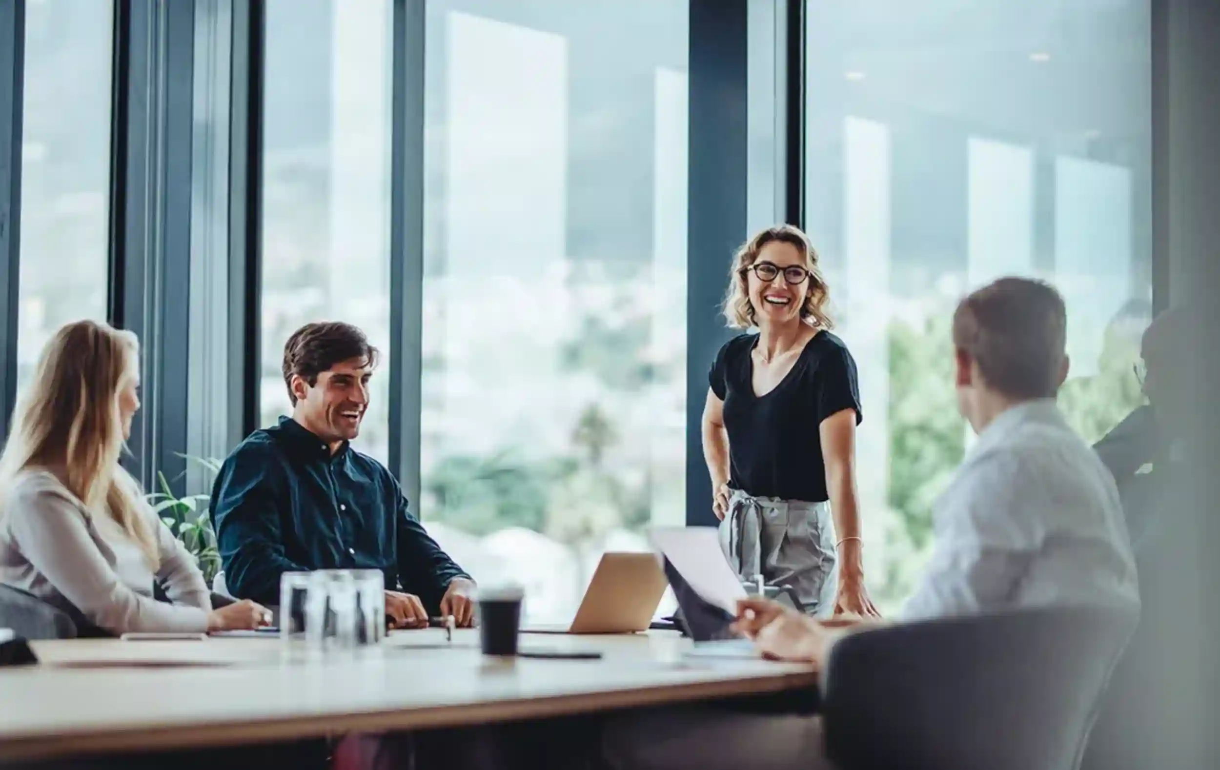 5 employees enjoying a laugh during a meeting in the conference room