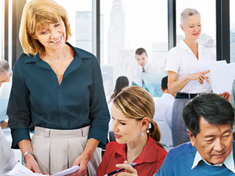 Coworkers talking, looking over one another at a casual meeting.