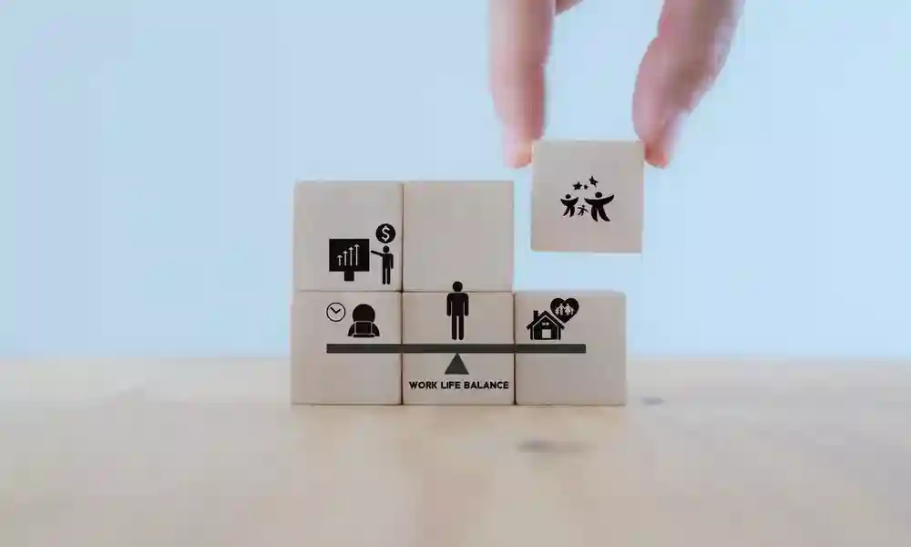 Wellbeing in the workplace and work life balance visualised in wooden blocks