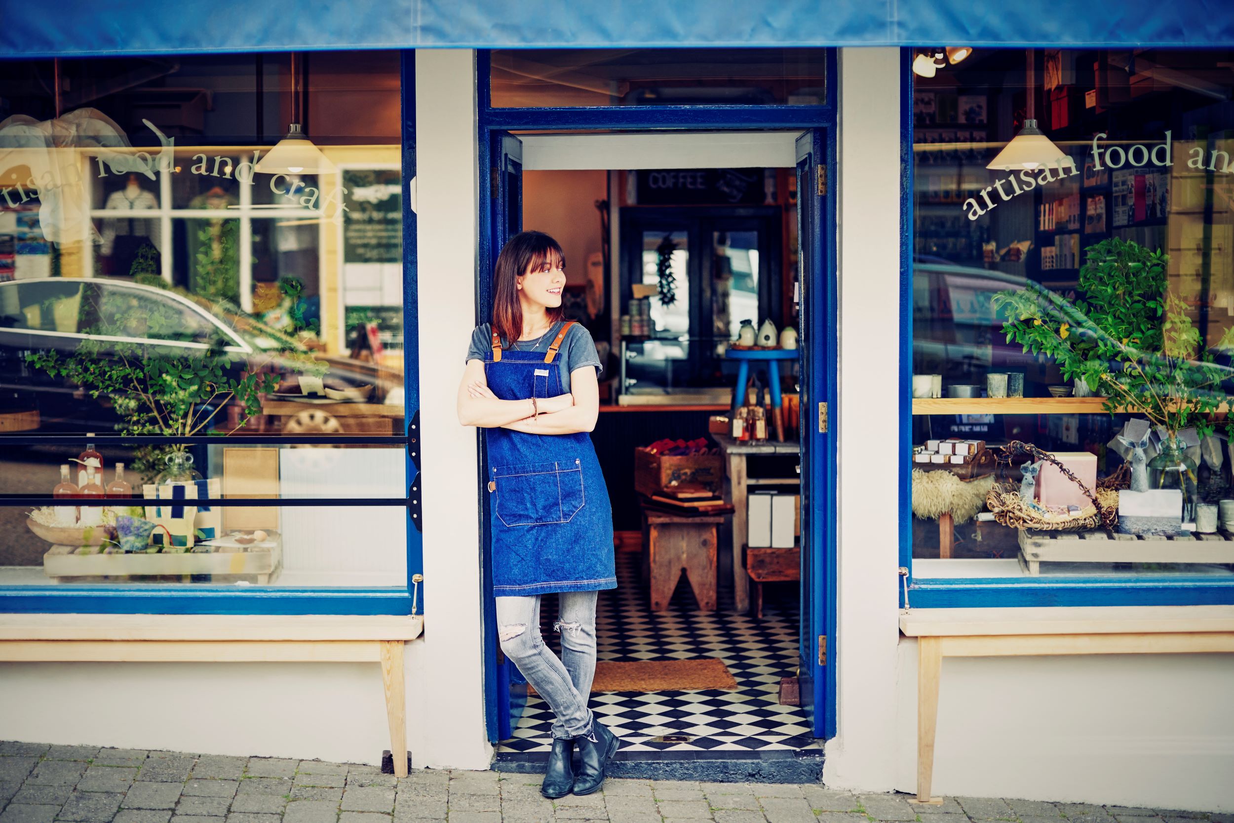 Smiling business woman standing outside of her shop.