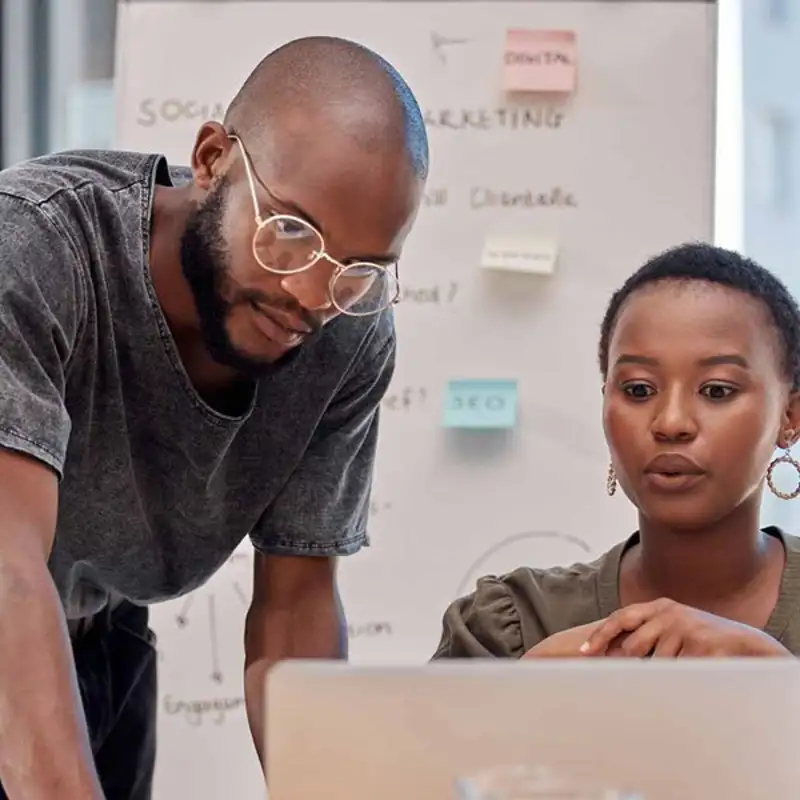 Two coworkers looking at a computer.
