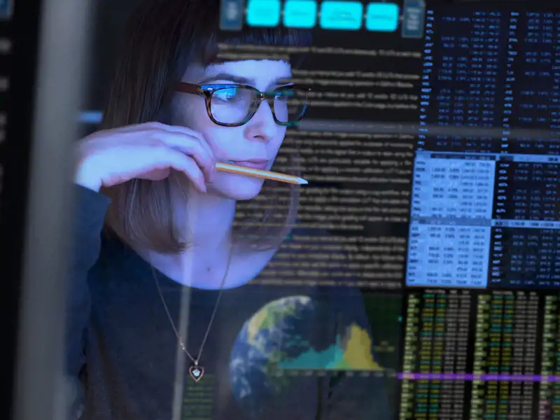 A woman analyzes data on a computer screen 