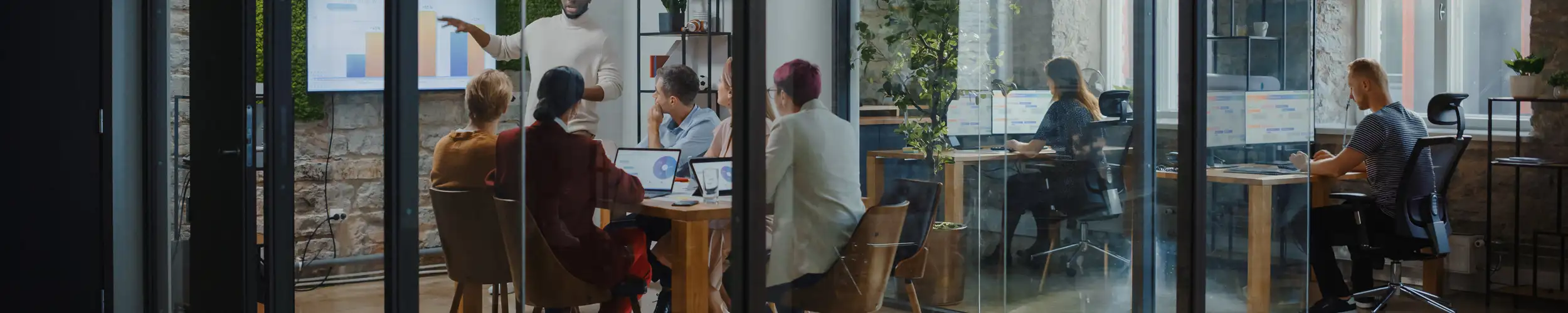 Employees in a conference room attending an internal organisational change presentation